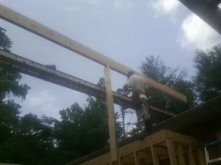 Carpenter setting a ridge beam over a new addition frame — Ice Dam Removal by Roofing Brothers in Rapelje
