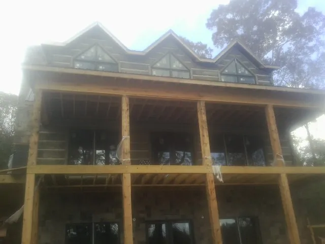 Dormers and porch framing on a large log home under construction — Roof Coating work by our crew in Rapelje