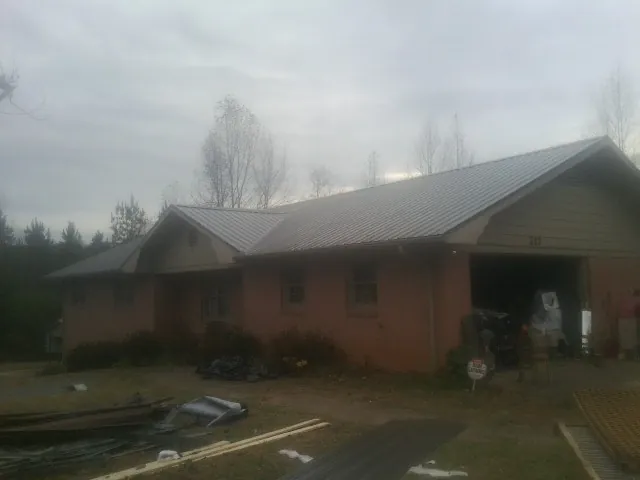 Gray metal roof on a stucco house with an attached garage in Rapelje